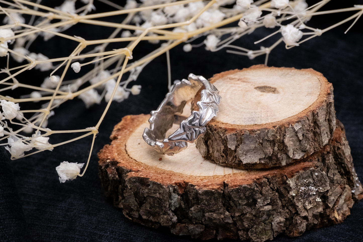 wide silver ivy leaf ringon wood with flowers