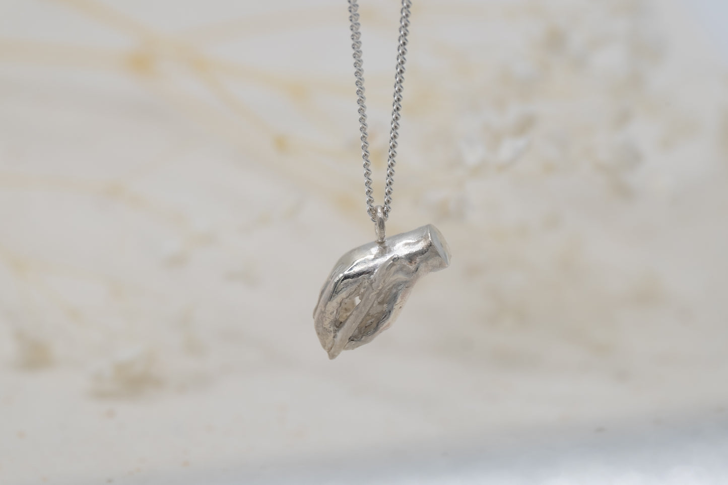 a writing hand necklace for women