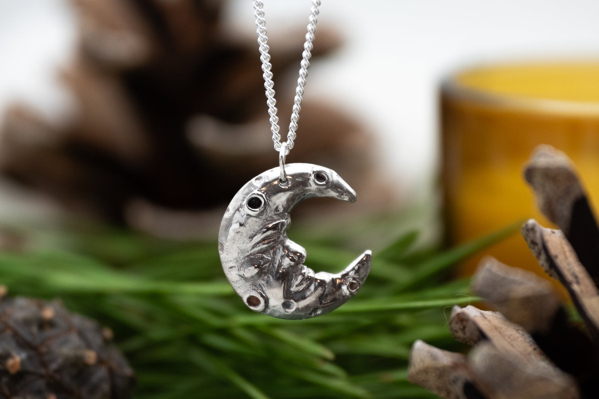 a silver crescent man in the moon pendant