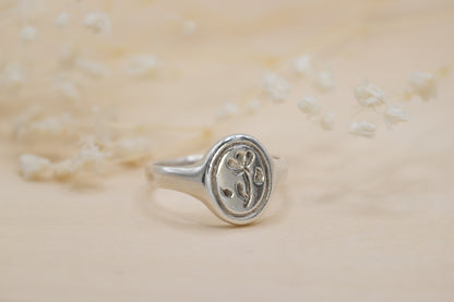 a silver floral signet ring