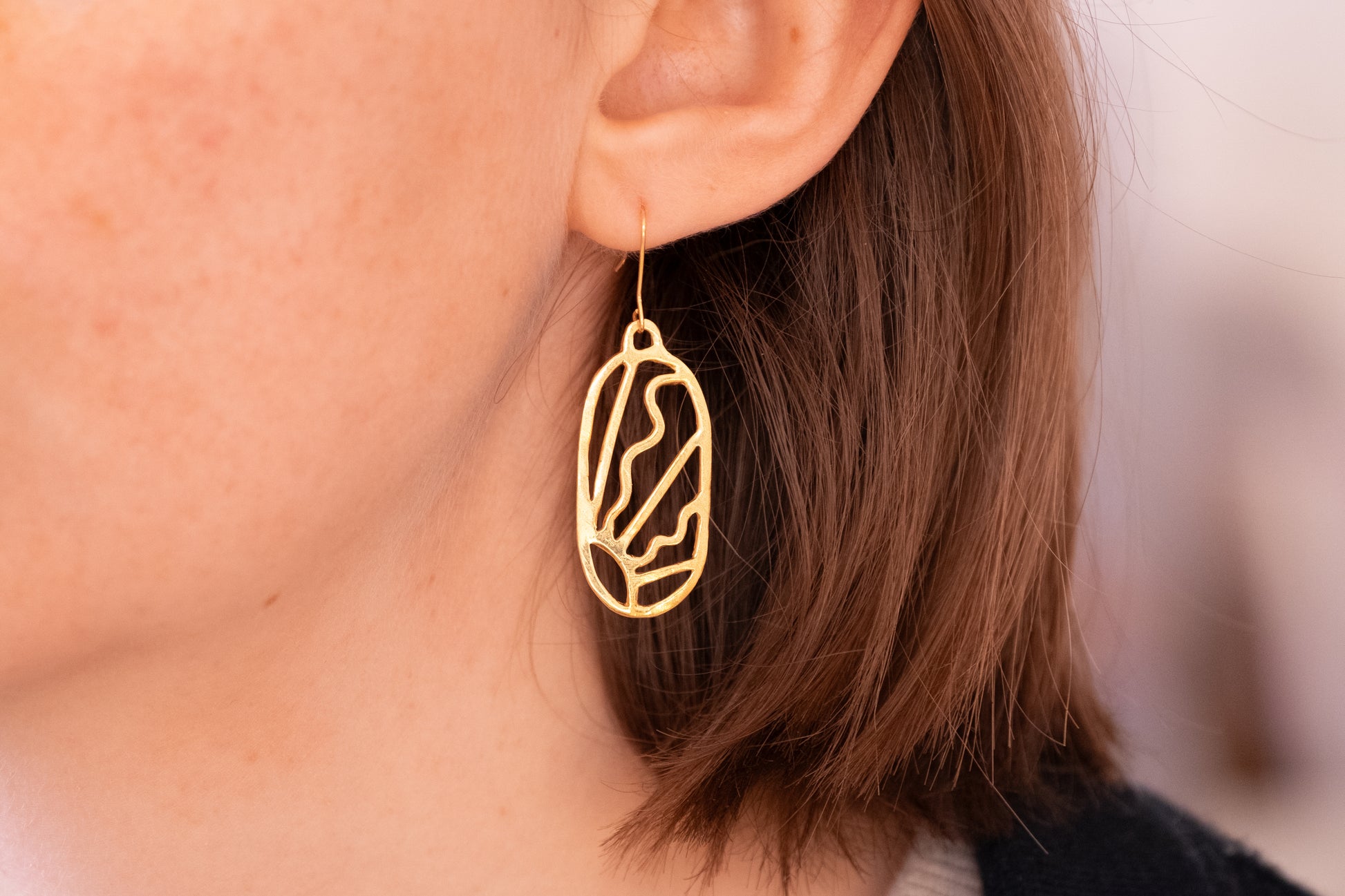 a large art deco sunbeam drop earring in gold plated silver