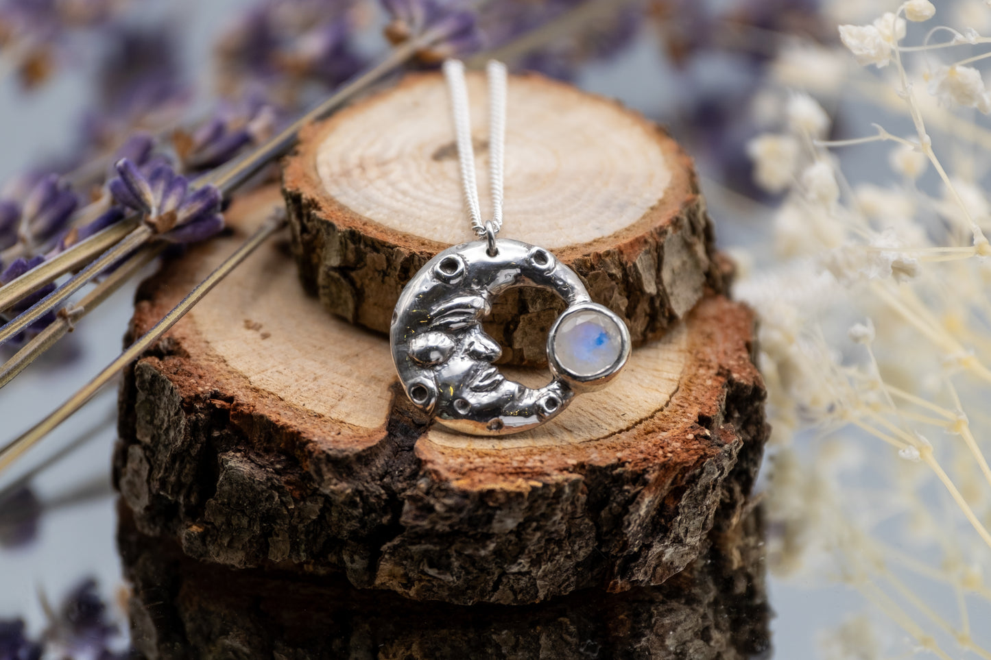 man in the moon silver pendant with moonstone on wood background