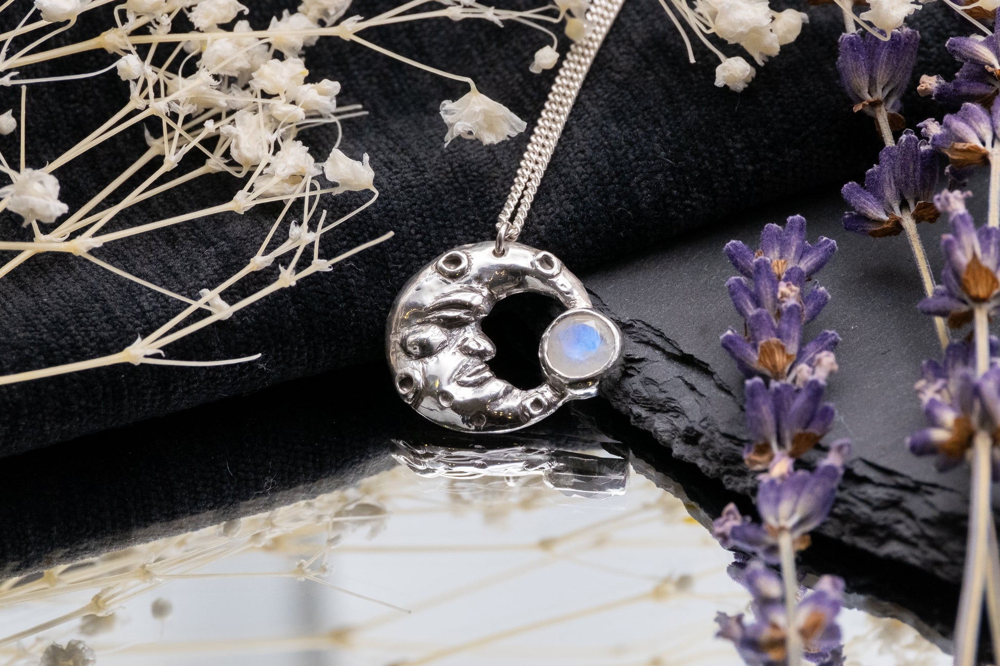 man in the moonstone silver pendant on mirror with lavender