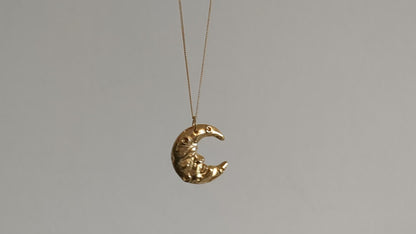 a gold plated hand carved crescent moon pendant