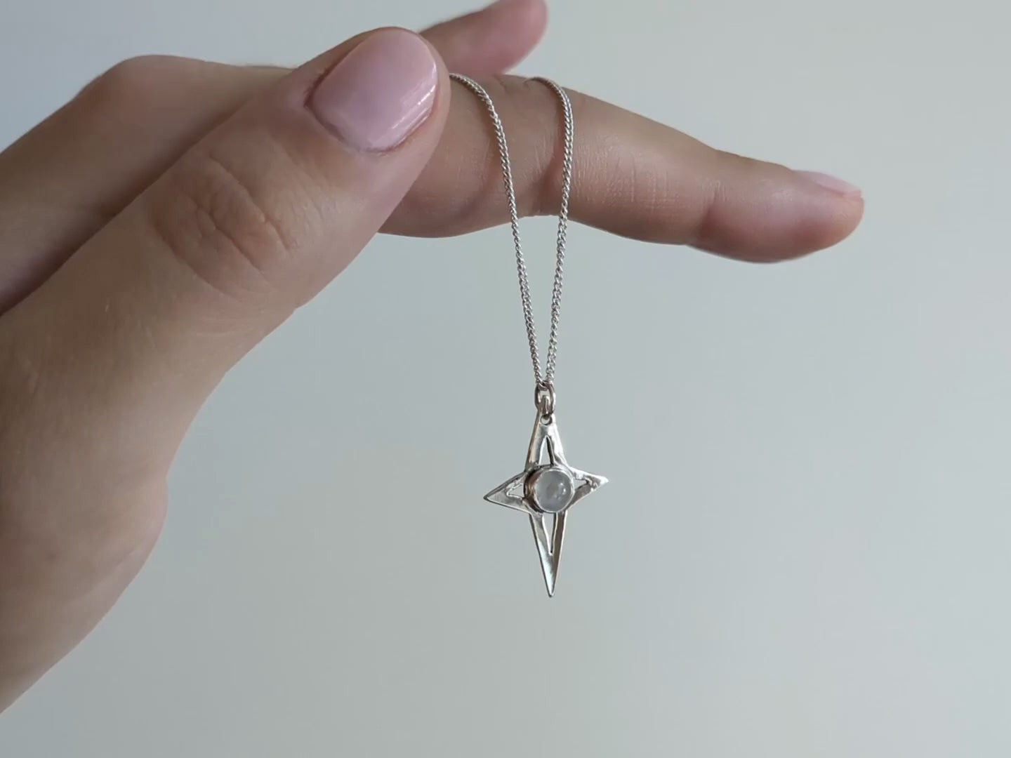 video of my magic moonstone star pendant hanging from my hand