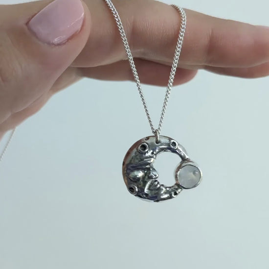 video of my silver man in the moonstone pendant hanging from my hand