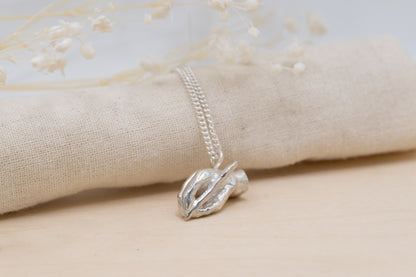 a silver writing hand pendant necklace